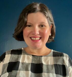 Portrait photo of Anita Carter, white woman with short brown hair, wearing a black and white checkered blouse.