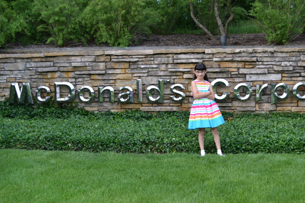 Hannah in front of McDonald's sign, demanding the corporation stop all harmful marketing practices to children. 