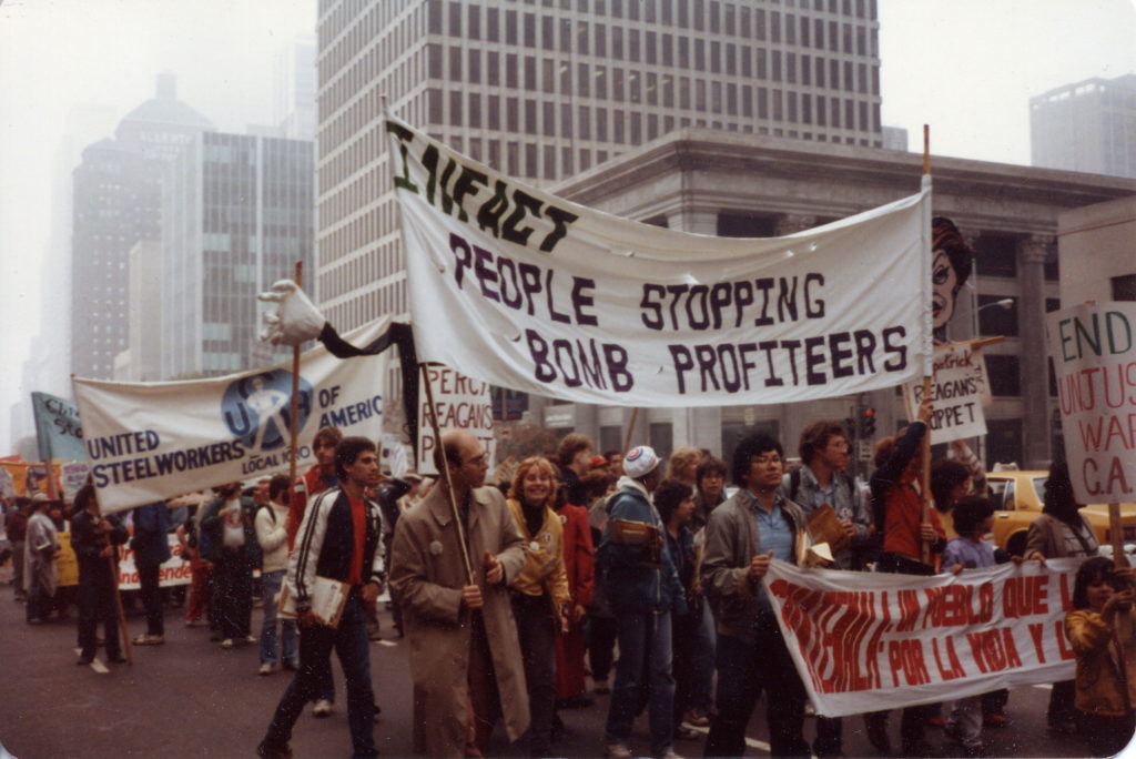 Infact members and supporters march with banners opposing G.E.'s nuclear weapons arm.