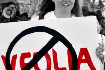 Corporate Accountability organizer exposes Veolia's abuses at protest.