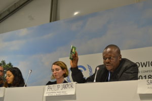 Philip Jakpor of ERA and FoENigeria holds up the Peoples Demands booklet at the official Fork in the Road UNFCCC side event.