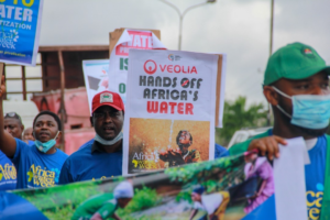 African water protectors march with signs rejecting water privatization