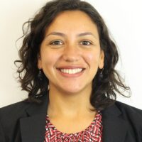 Portrait of Nathalie Rengifo Alvarez, organizer and spokesperson at Corporate Accountability. Nathalie has light brown skin, and dark, wavy hair that falls to her shoulders. She wears a black blazer and red shirt.