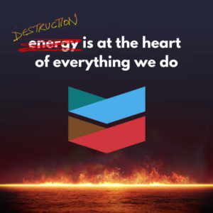 Blue and red Chevron logo rises flames. The corporation's tagline, "energy is at the heart of everything that we do," with the word energy scratched out in red and destruction written above it, is positioned above the logo.