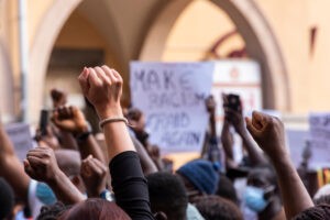 People raise their fist in the air at a protest.