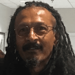 Photo of Julian Kunnie, wearing glasses and long dread locks.