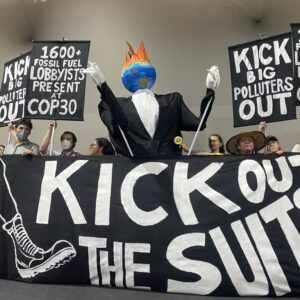 Protest with a giant sign reading "Kick out the suits"