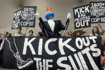 Protest with a giant sign reading "Kick out the suits"